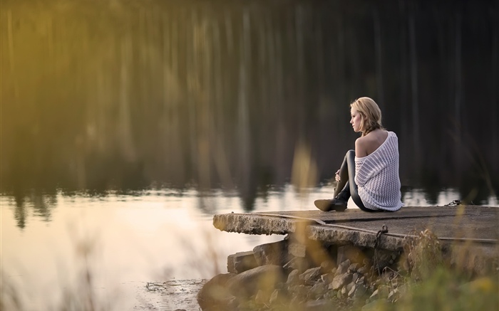 소녀는 호수쪽에 앉아있다. 배경 화면 그림